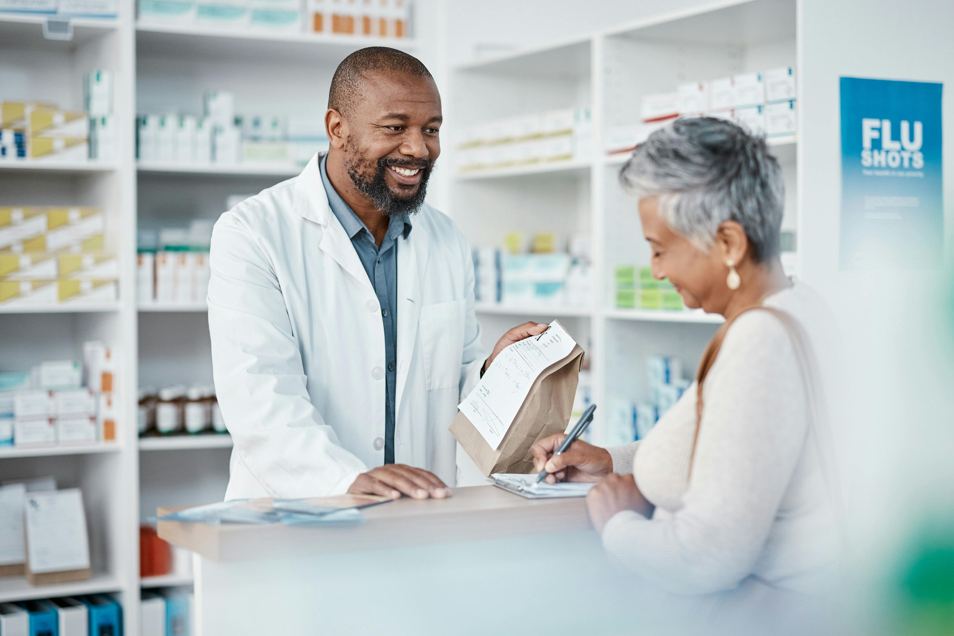 A pharmacist hands medication to a patient / Clayton D/peopleimages.com - stock.adobe.com