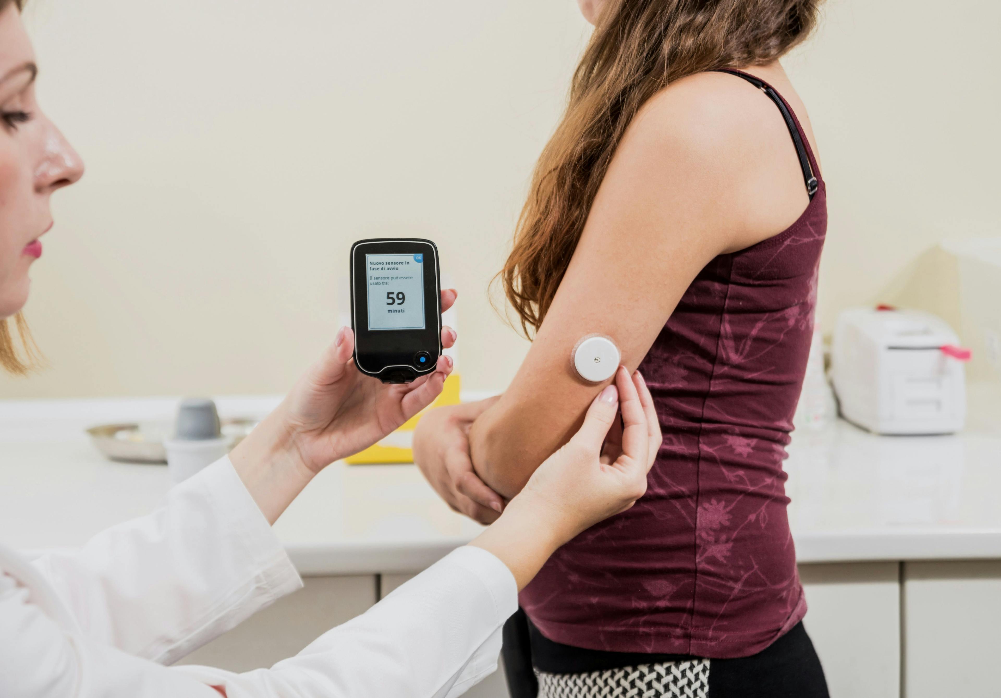 Pharmacist helping patient with CGM / romaset - stock.adobe.com