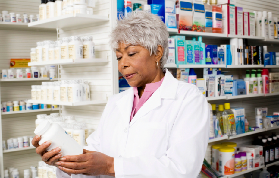 pharmacist checking label on pill bottle