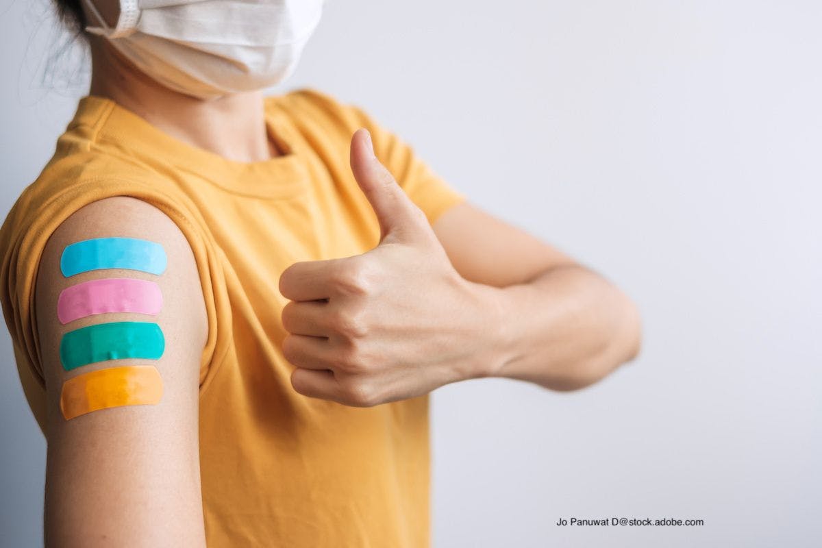 Woman has 4 bandages on her upper arm indicating 4 doses of a vaccine