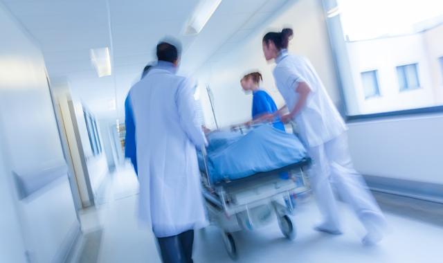 healthcare team rushing patient on a bed
