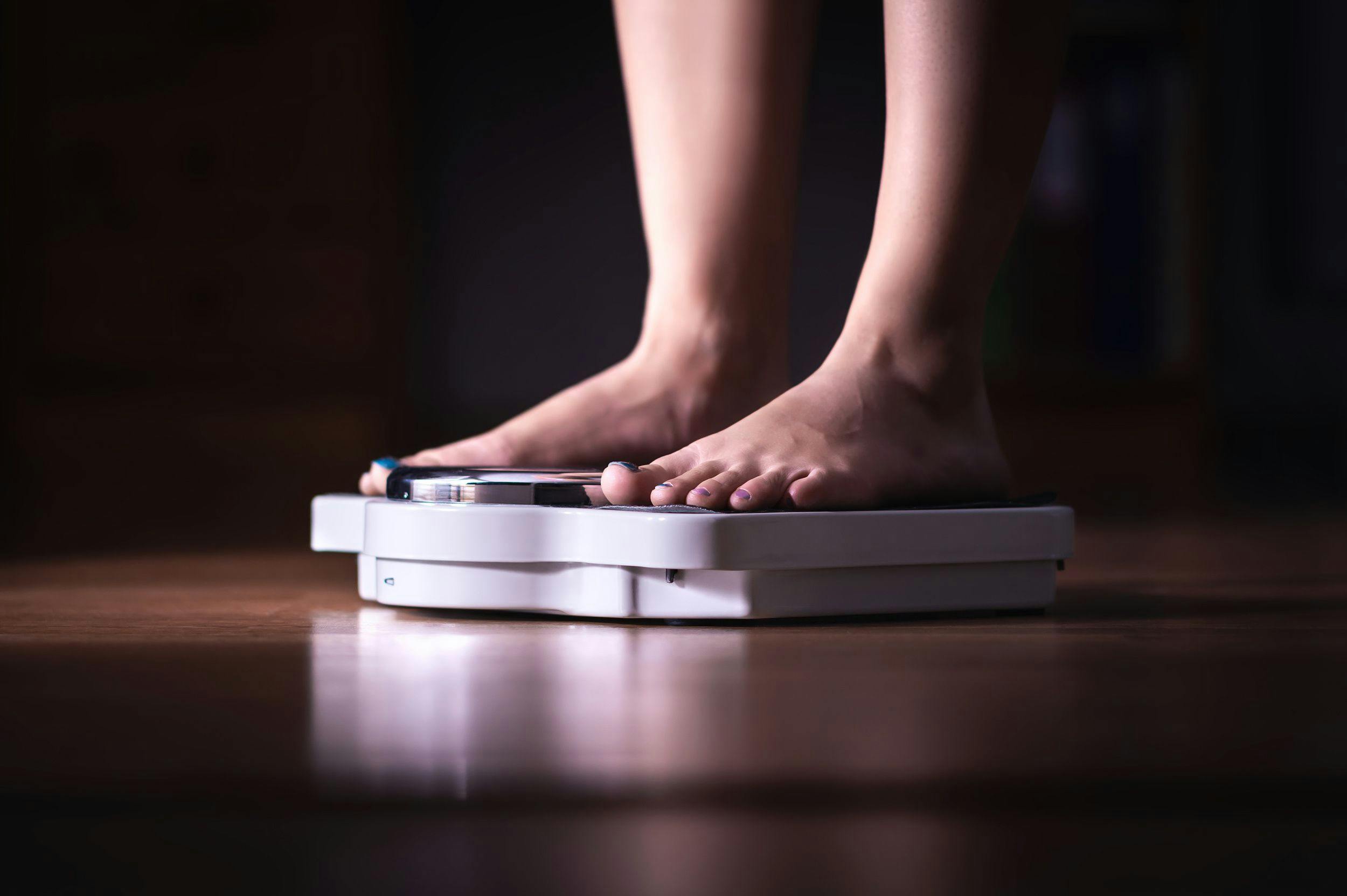 Person stepping on scale / terovesalainen - stock.adobe.com