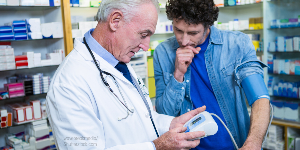 Pharmacist taking blood pressure of patient
