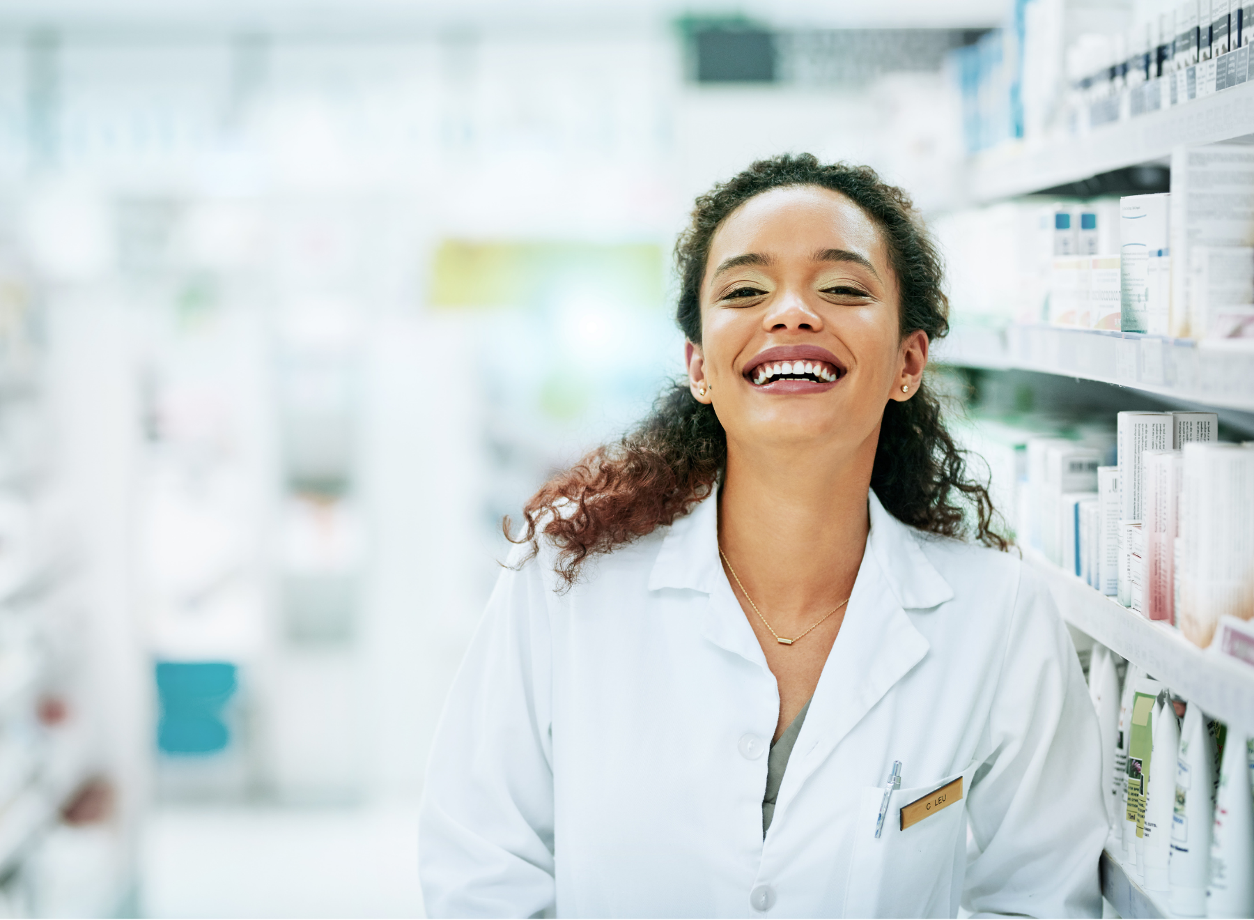 Pharmacist smiles in pharmacy aisle