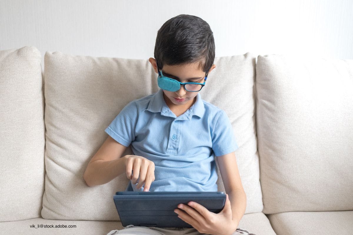 young boy with amblyopia looking at tablet
