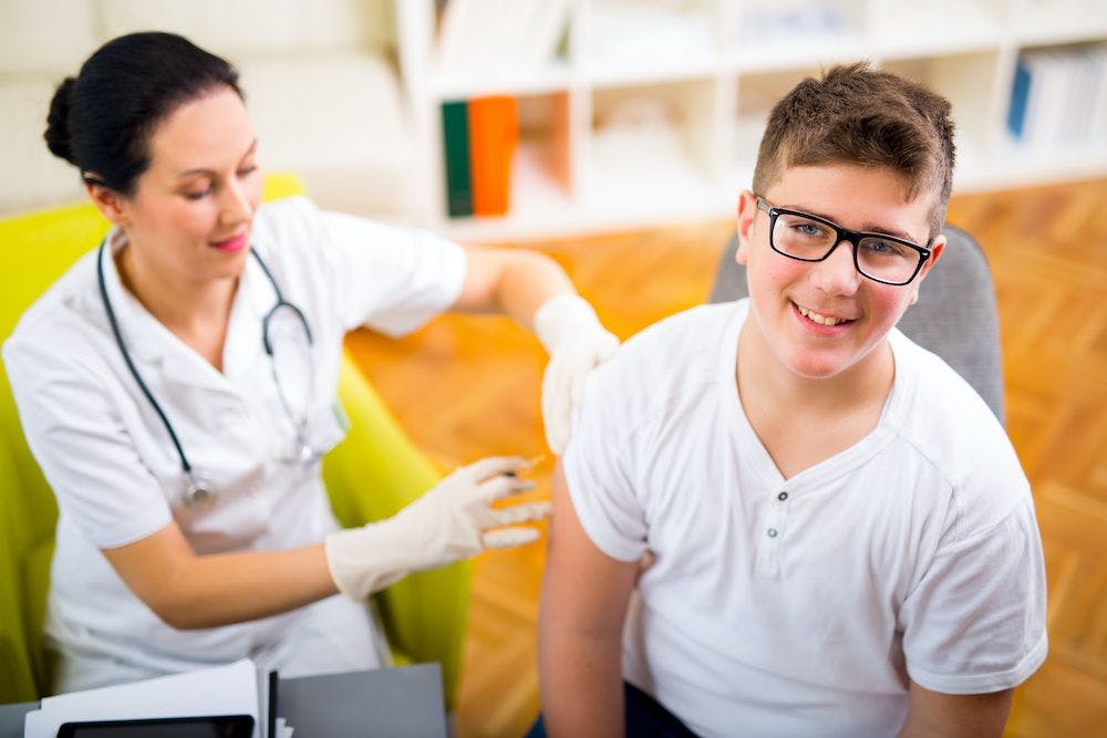 Teen receiving vaccine
