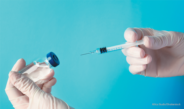 gloved hands holding syringe and vaccine vial